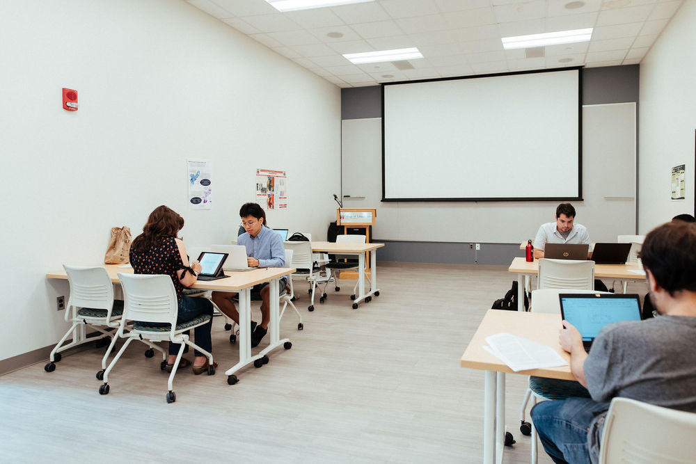 Five College of Liberal Arts students work on their computers in a classroom.