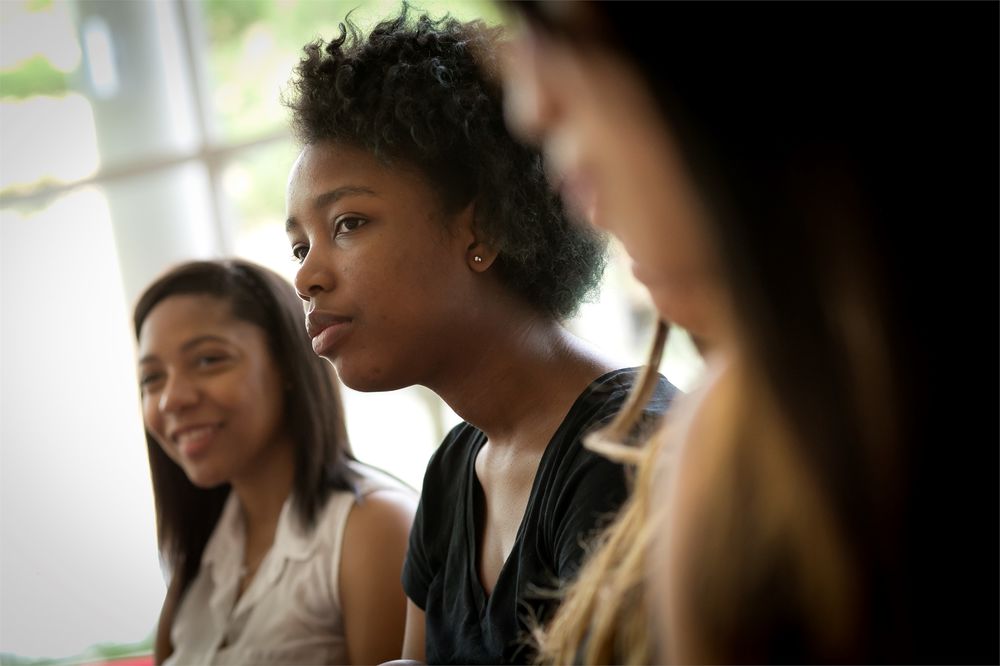 Female students engage in a classroom.