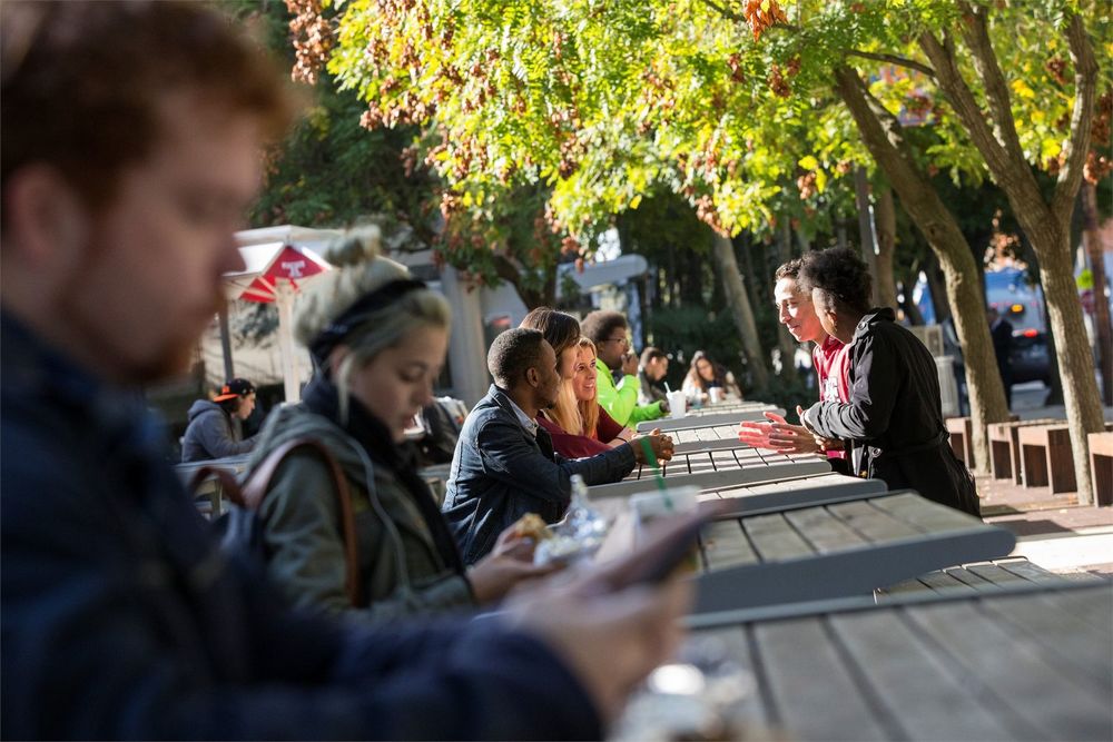 Students talking and sitting outside on campus.