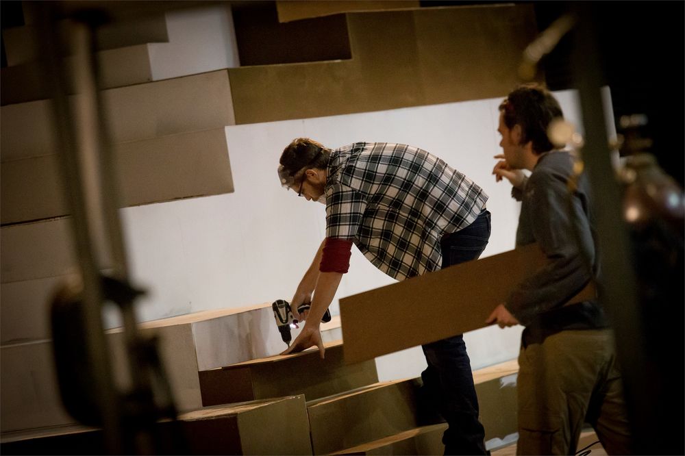 Student backstage building a prop for a theater set.