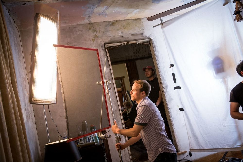 A film student setting up equipment on a film set.