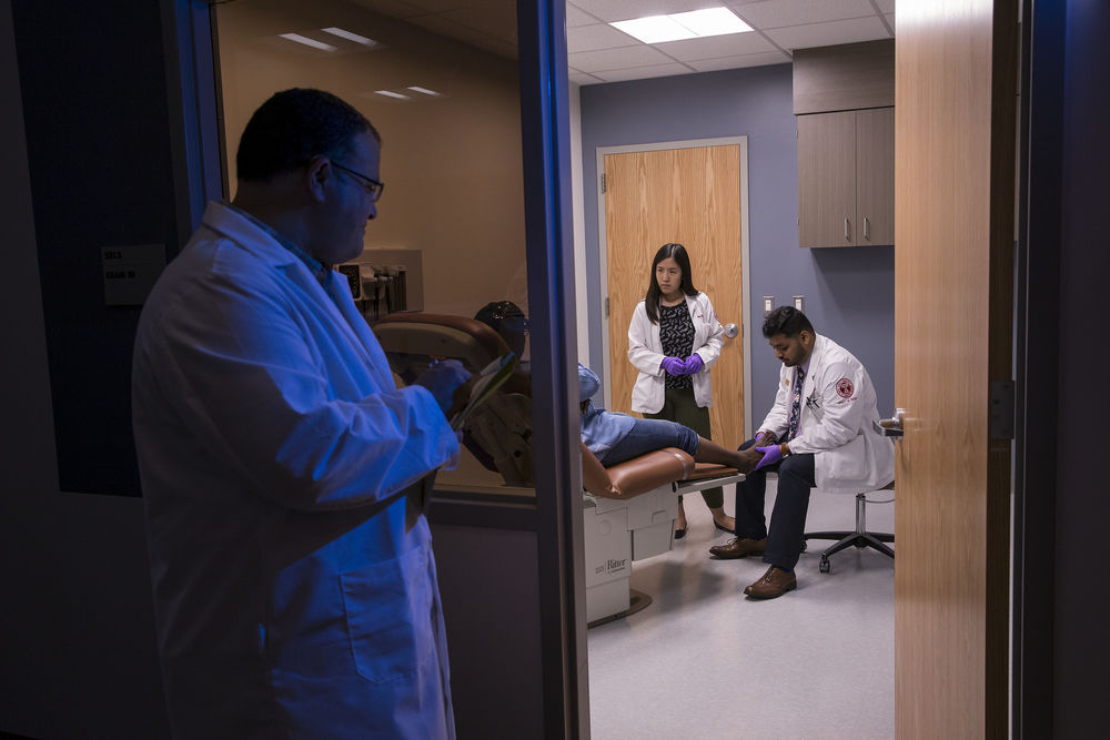 Podiatric students examine a patient.