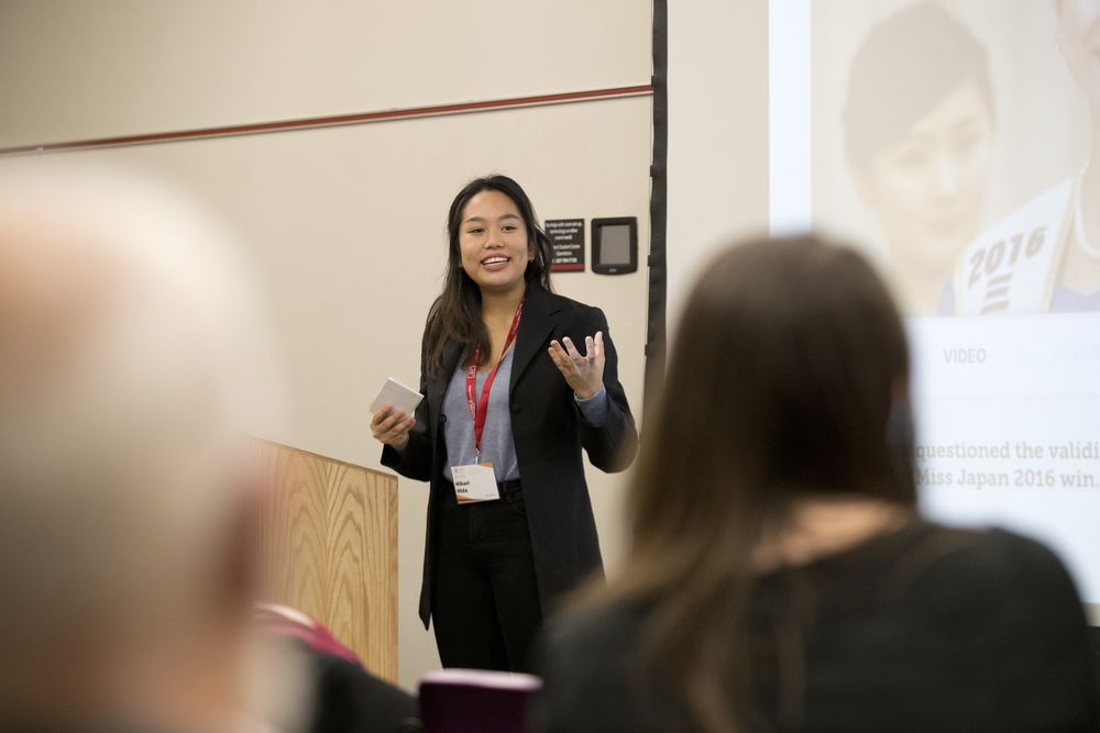 Female student, note cards in hand, addresses the crowd at a Temple event.