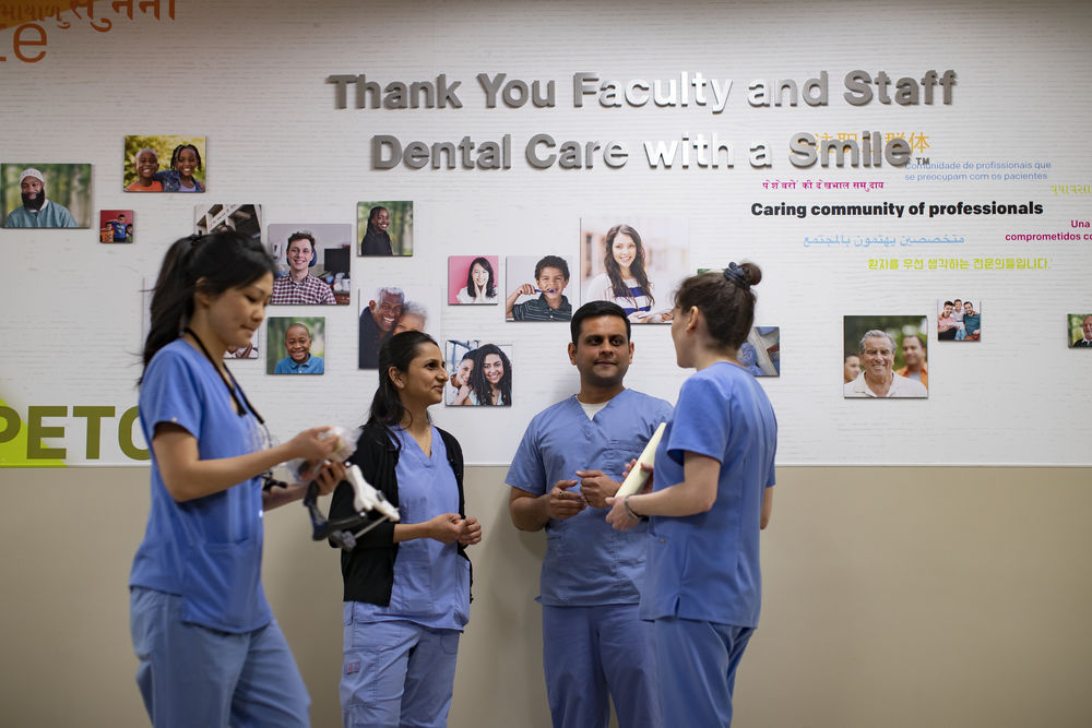 International dental school students conversing in a hallway. 