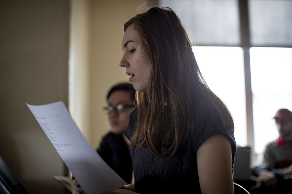 Student reading out loud from a paper in a classroom. 