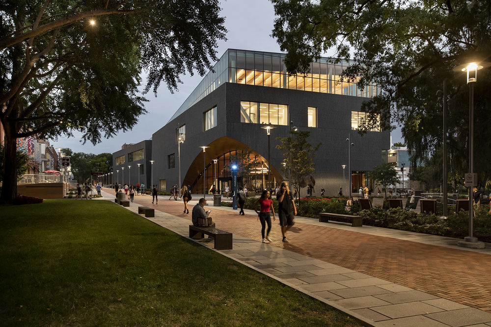 students walking along Liacouras Walk in the evening near Charles Library