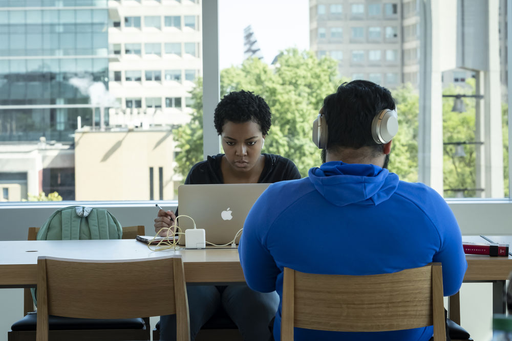 Two students work in front of a window in Charles Library.