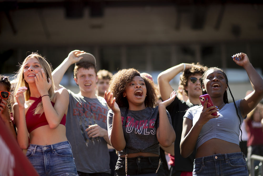 Four Temple students cheering on the Temple Owls football team at Homecoming