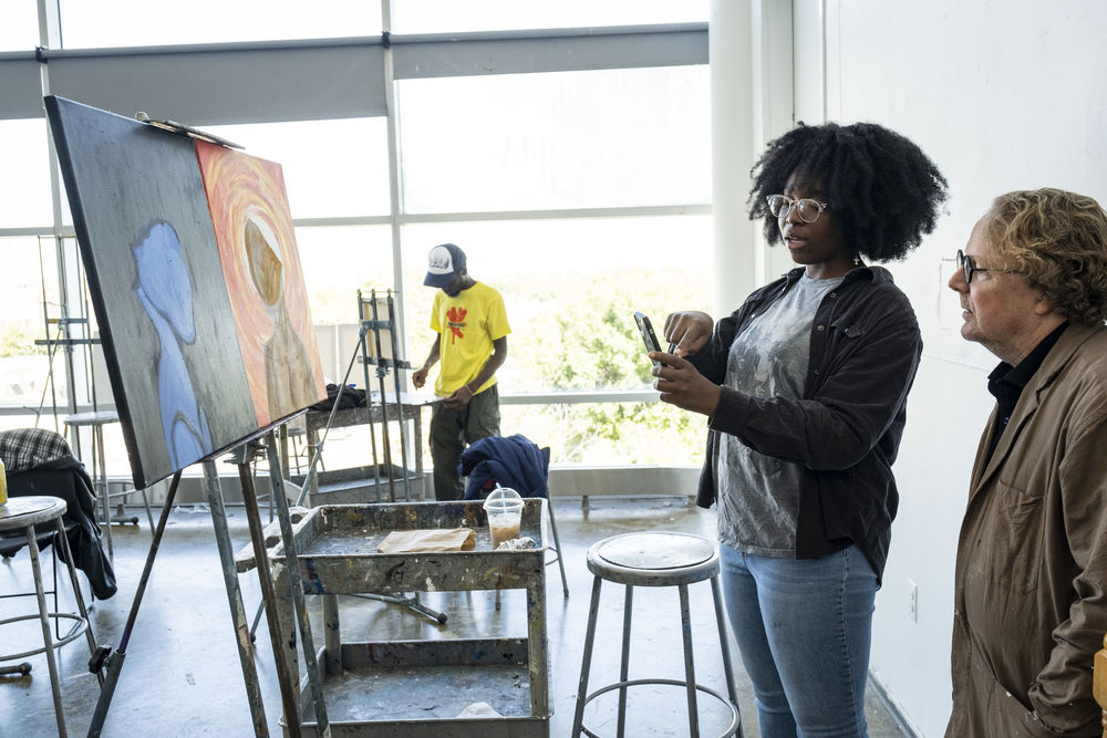 painting student discusses work with professor.