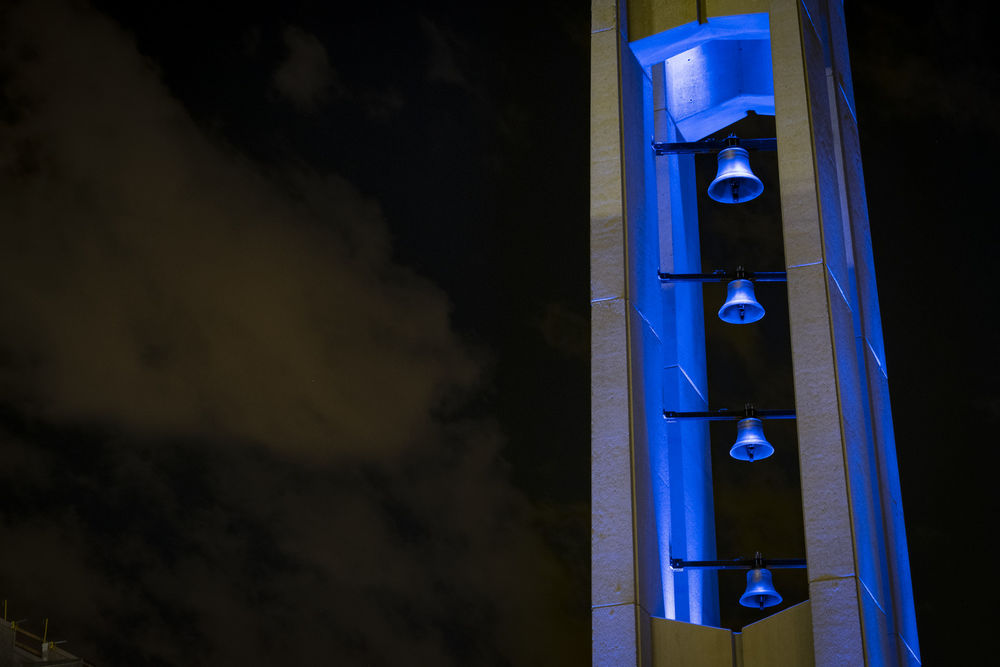 the Bell Tower on Main Campus illuminated with blue lights.