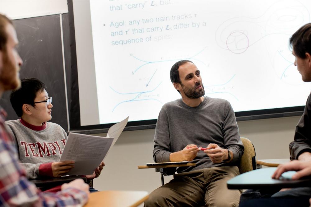 A teacher consults a group of students regarding a difficult proof.