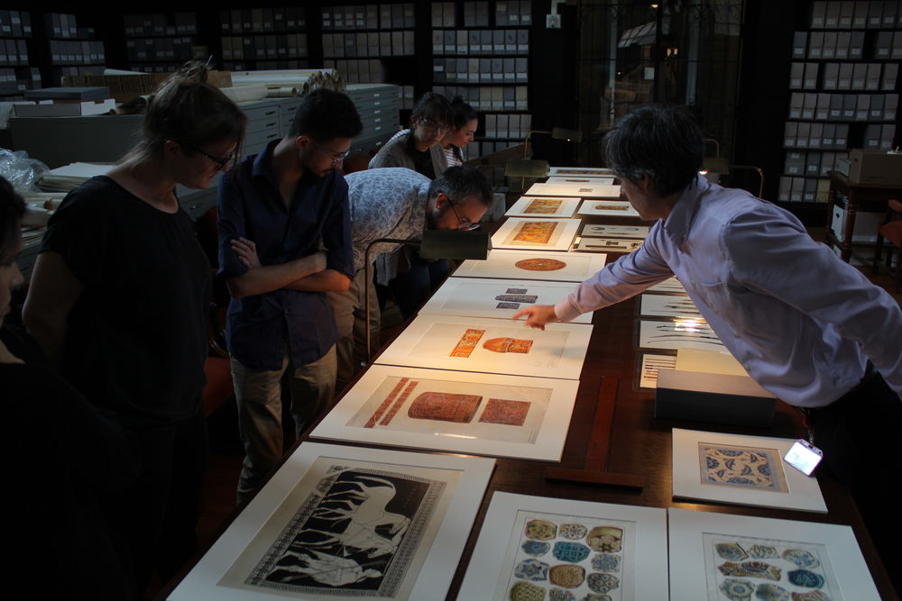 Tyler faculty examines prints with students. 