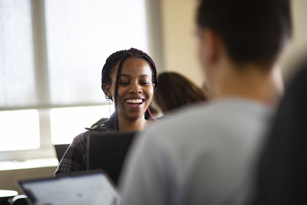 A Temple student laughs along with her peers during class discussion.