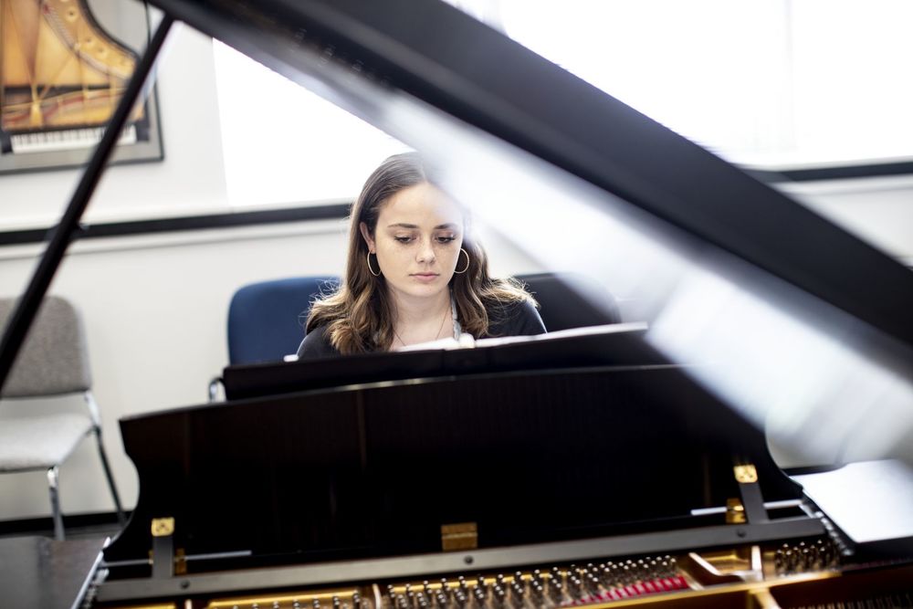 A Boyer College of Music and Dance student plays the piano in a rehearsal room on Temple's campus.