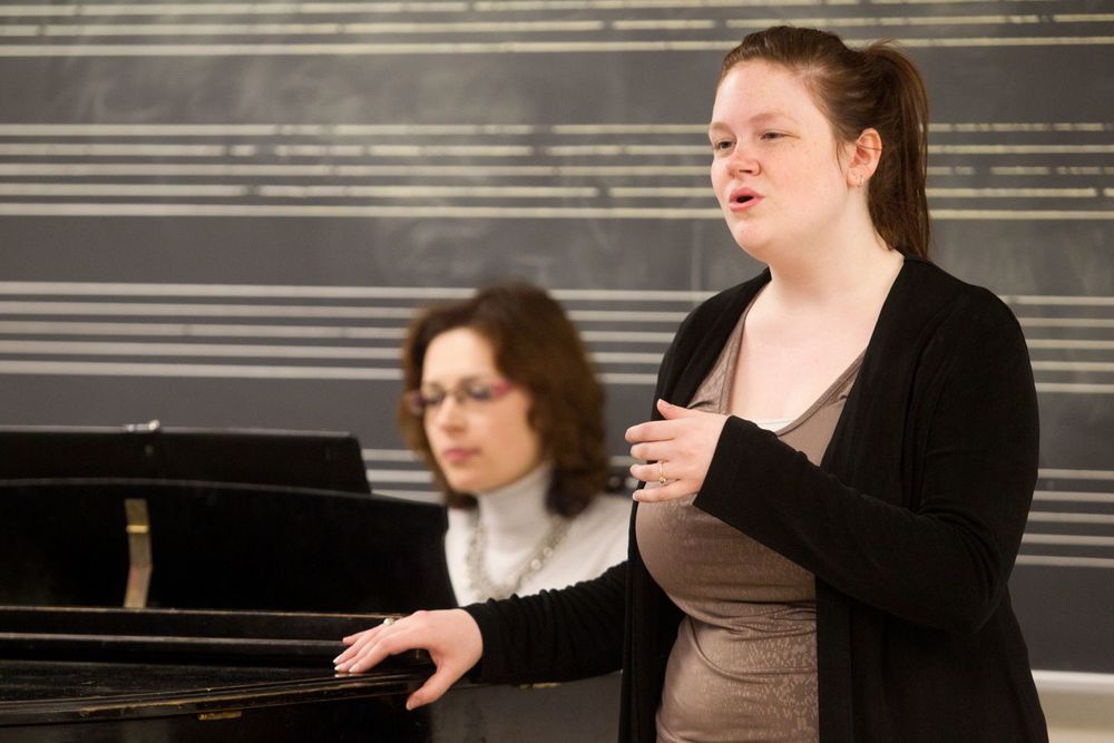 A Boyer College of Music and Dance student sings while a woman plays the piano.