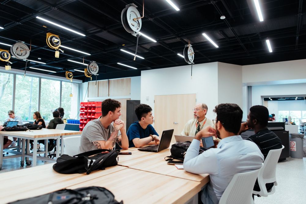 A Temple professor meets with a group of students in an engineering lab.