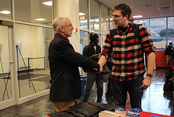 Engineering management certificate student shaking hands with faculty