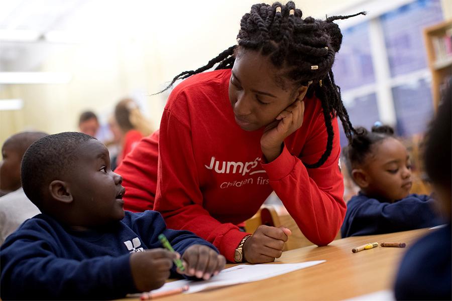 education student working with a young learner in elementary school classroom