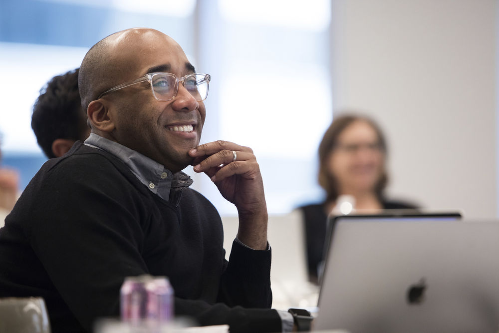 A Temple professor smiles during a student presentation.