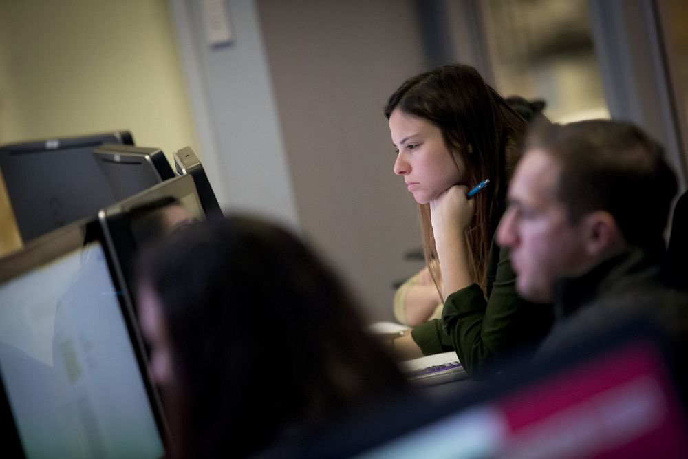 Temple students study the array of screens in the computer lab.