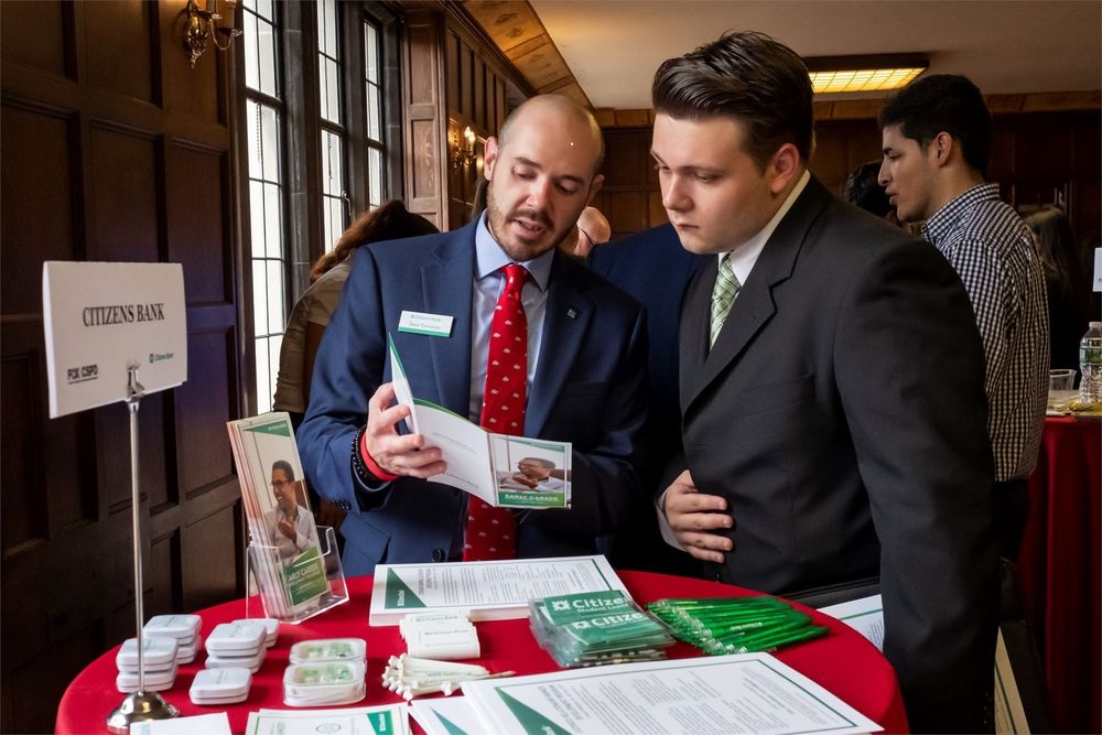 A Fox student converses with representatives of a local company.