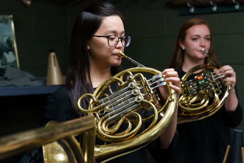 Two Temple University Boyer College of Music and Dance students play the french horn.