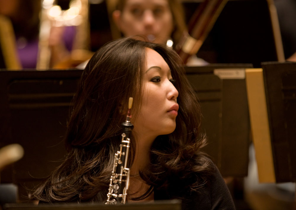 Woman in a chair holding a clarinet.