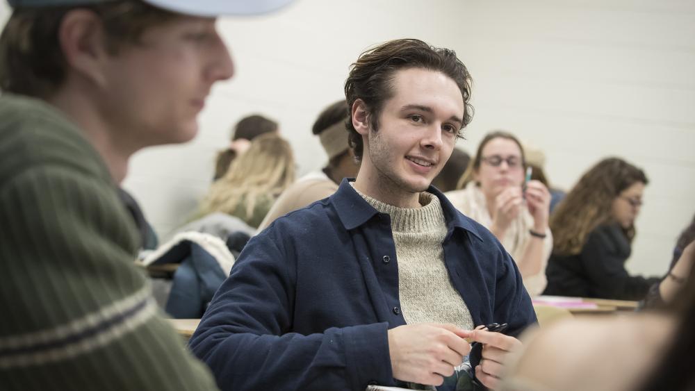 education student wearing a dark blue shirt participating in class