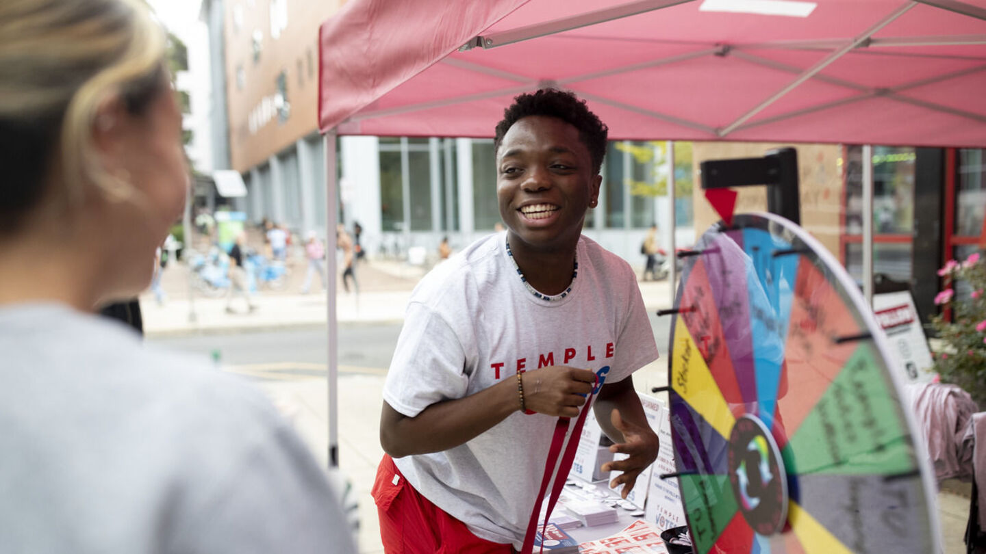 A Temple Votes ambassador with a student at a tabling event